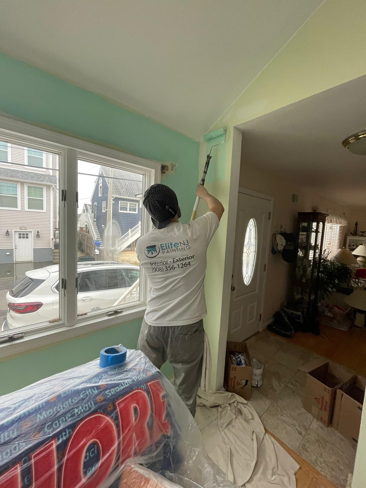 Elite NJ Painting crew member rolling a fresh coat on an interior wall